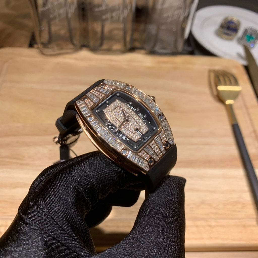 Luxury wristwatch with diamond-studded bezel and black dial on black strap