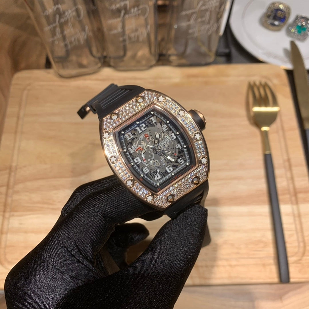 Richard Mille watch with jeweled tonneau bezel and dark dial, black rubber strap visible