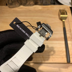 White watch strap with silver clasp and pin, underside close-up