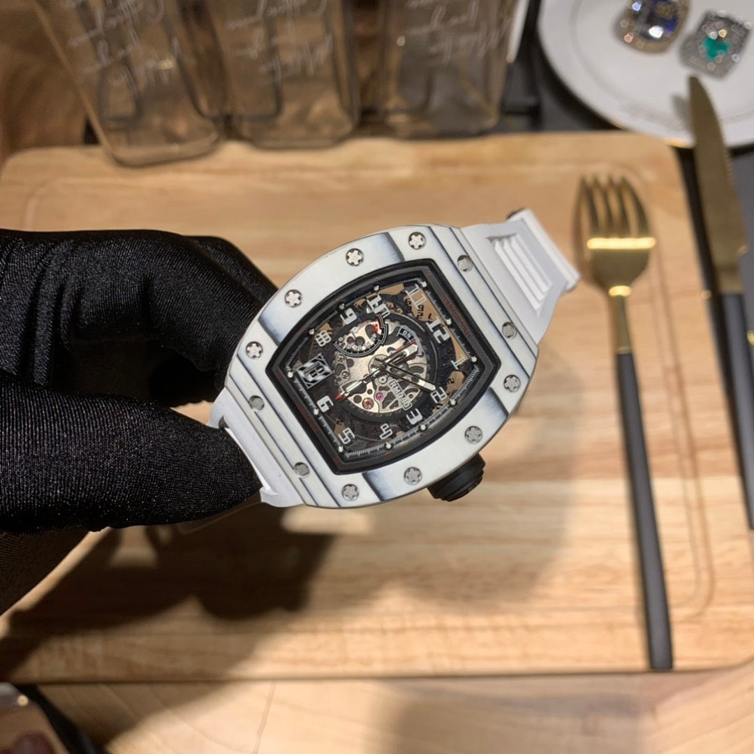 Richard Mille wristwatch close-up, silver case with black dial on gloved hand.