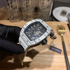 Richard Mille wristwatch three-quarter view, silver case with black dial.