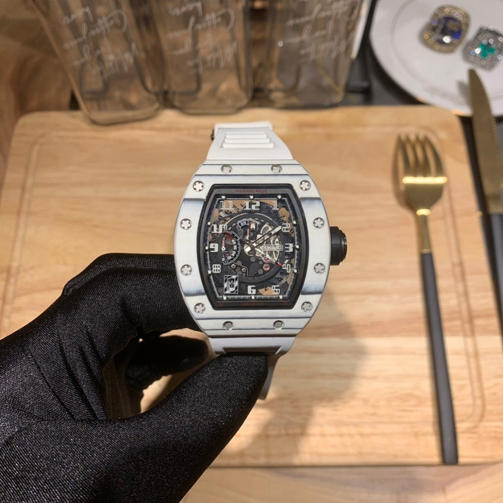 Richard Mille wristwatch with silver case, black skeleton dial on gloved hand.