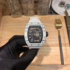 Richard Mille wristwatch with silver case, black skeleton dial on gloved hand.