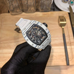 Richard Mille wristwatch angled view, silver case with black dial on gloved hand.