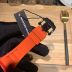 Orange watch strap and clasp, black strap detail with Richard Mille tag