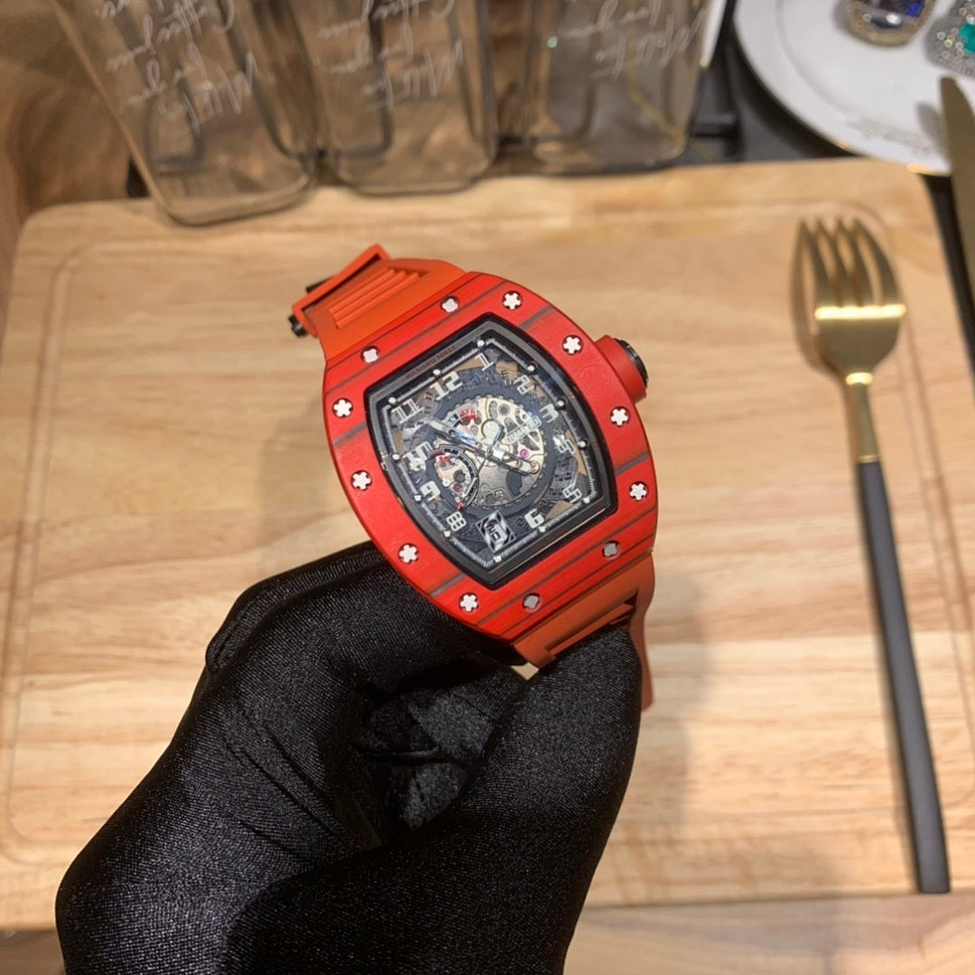 Orange sports watch with black dial, side hardware visible, gloved hand holding