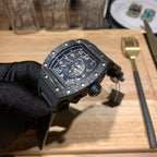 Richard Mille watch front view with black case, skeleton dial, and crown side knob