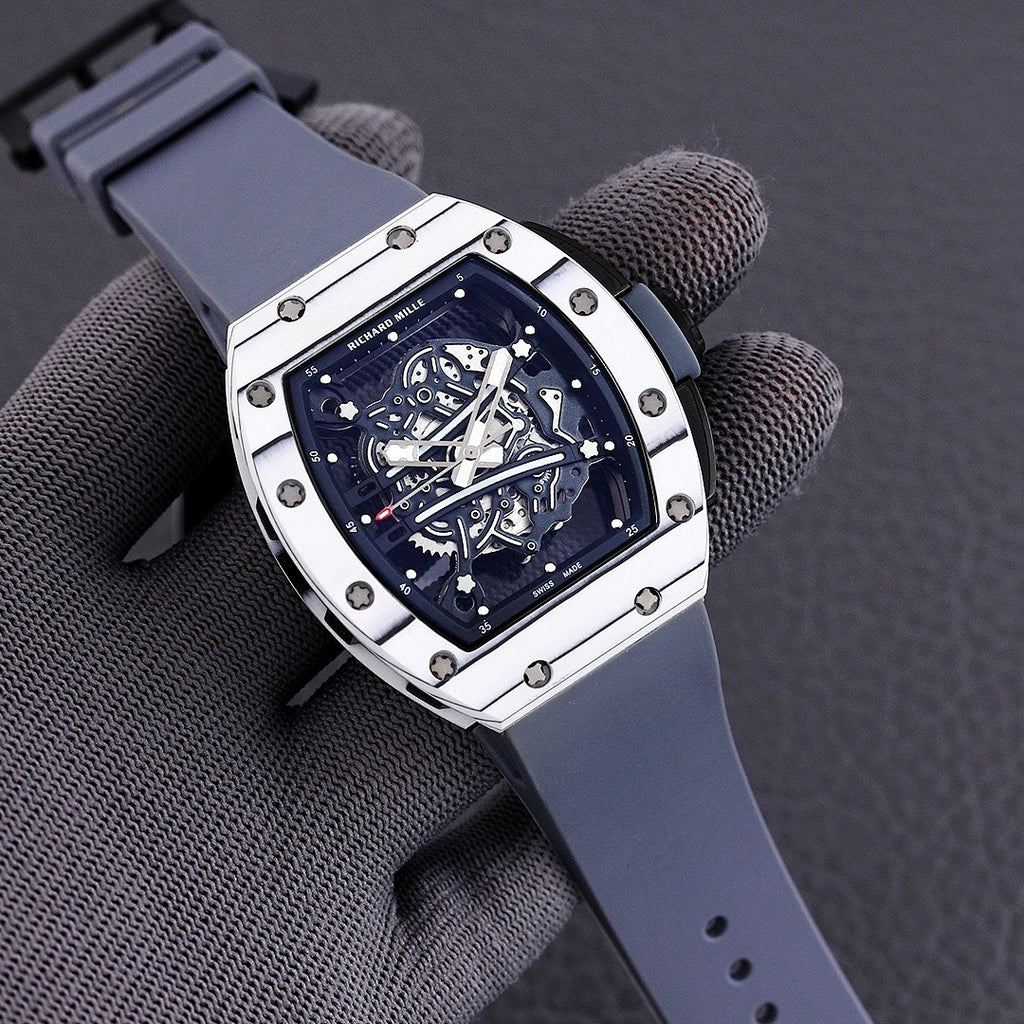 Richard Mille watch with white-toned case, blue skeleton dial, and slate blue rubber strap.
