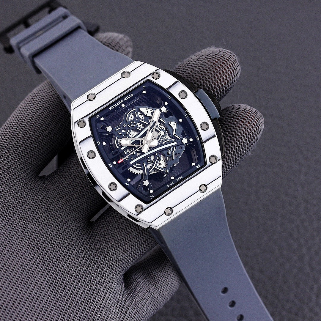 Richard Mille watch with white-toned case, blue skeleton dial, and slate blue rubber strap.