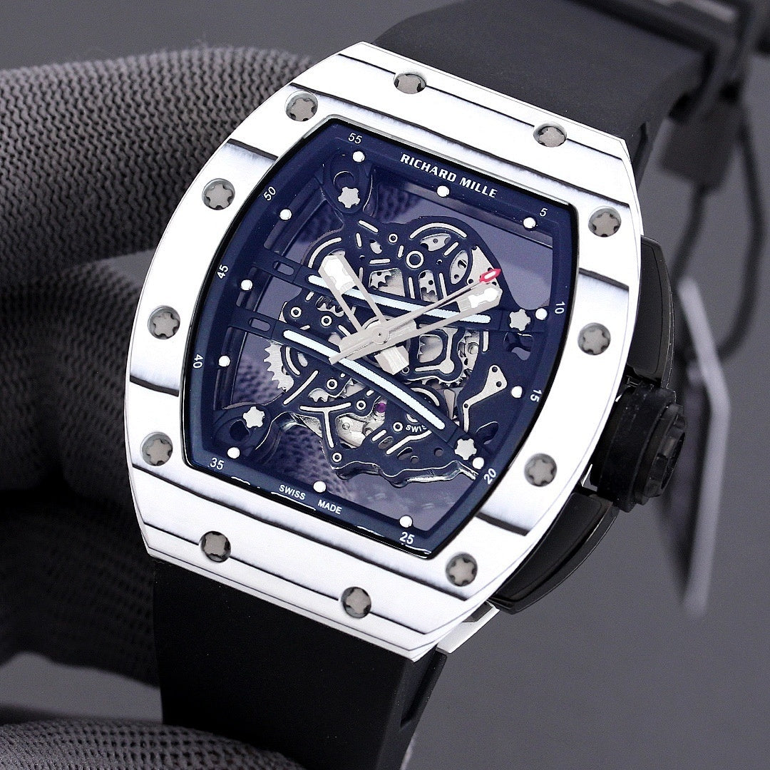Richard Mille watch with white-toned case, blue skeleton dial, and black rubber strap.