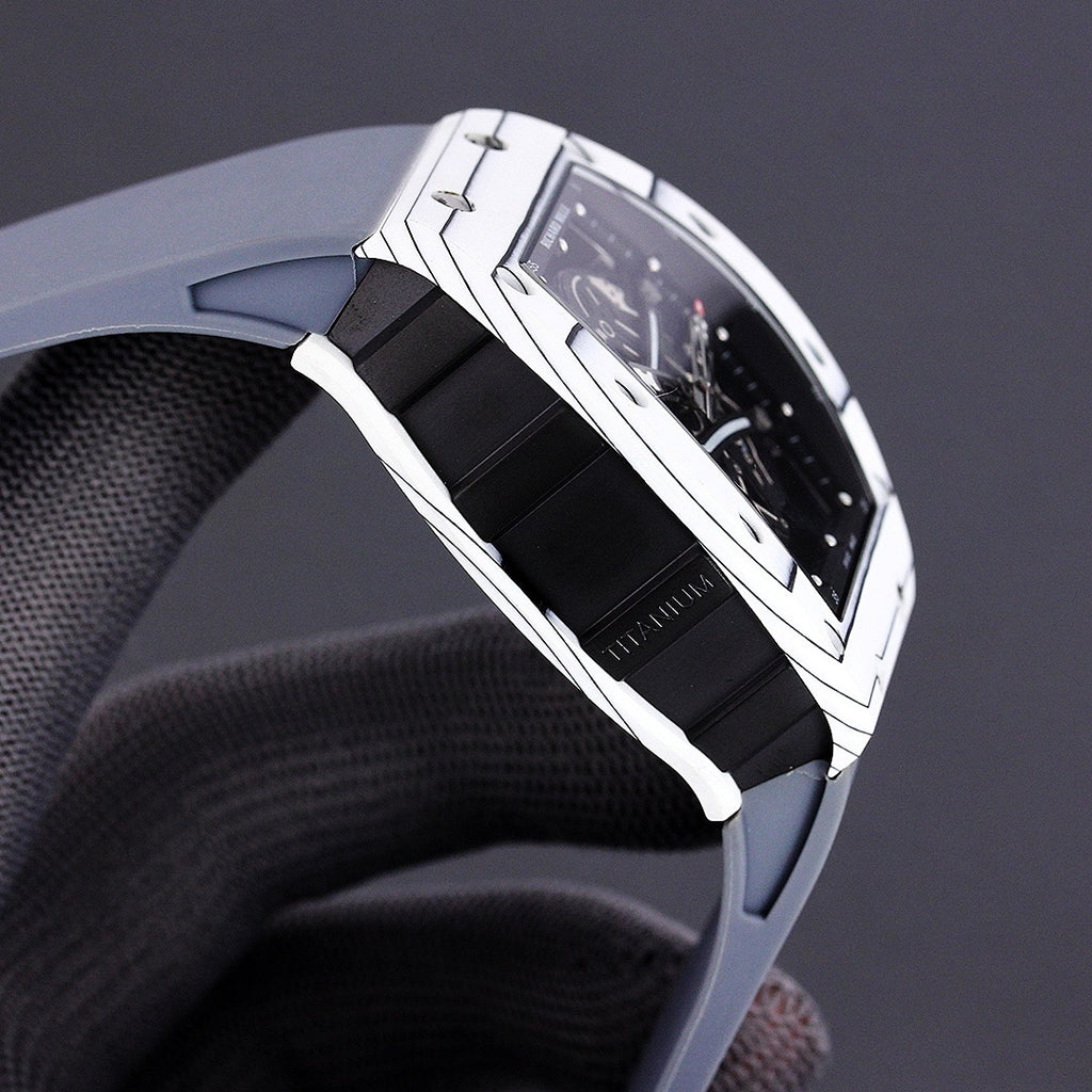 Richard Mille watch side view with white-toned case and black rubber strap.