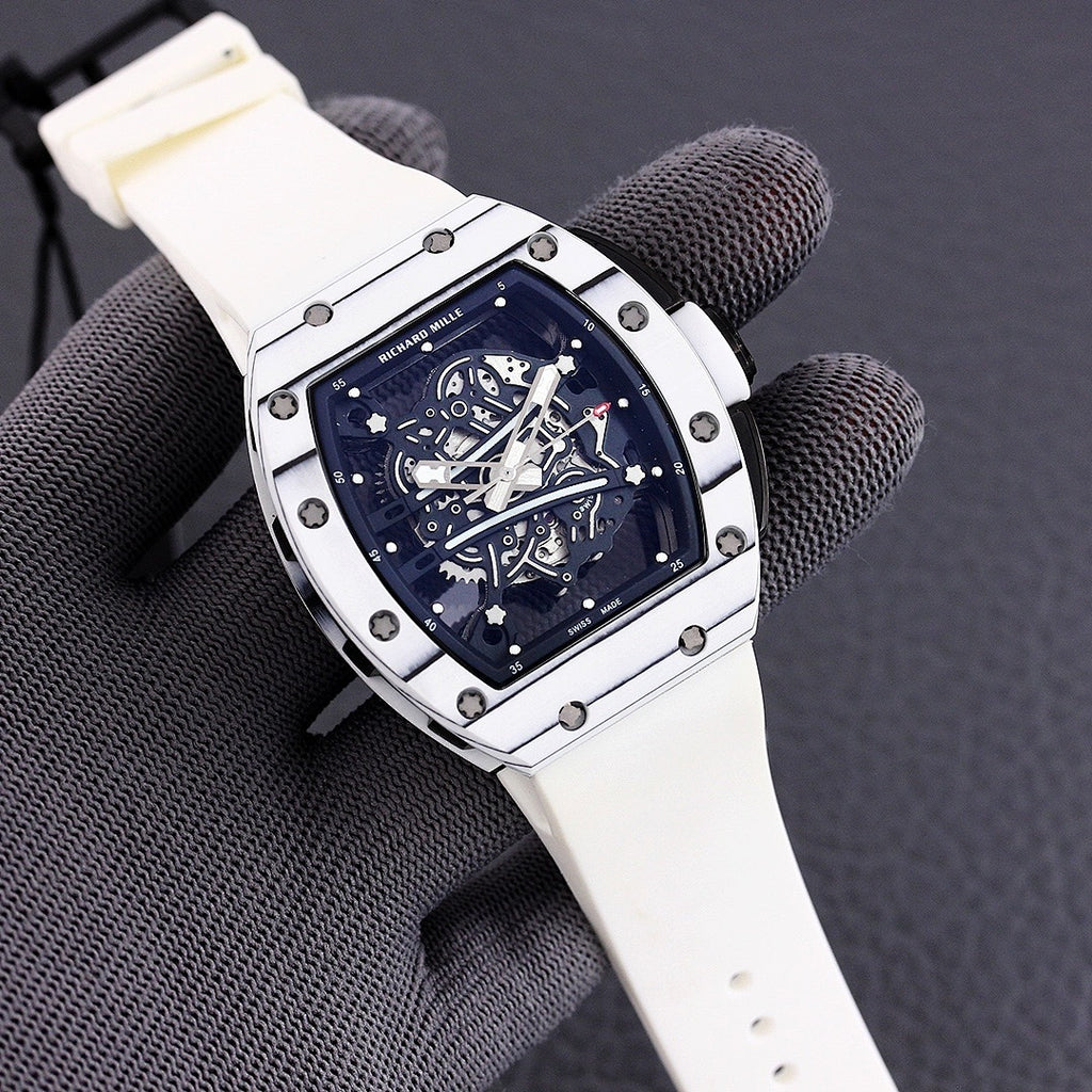 Richard Mille watch with white-toned case, blue skeleton dial, and light beige rubber strap.