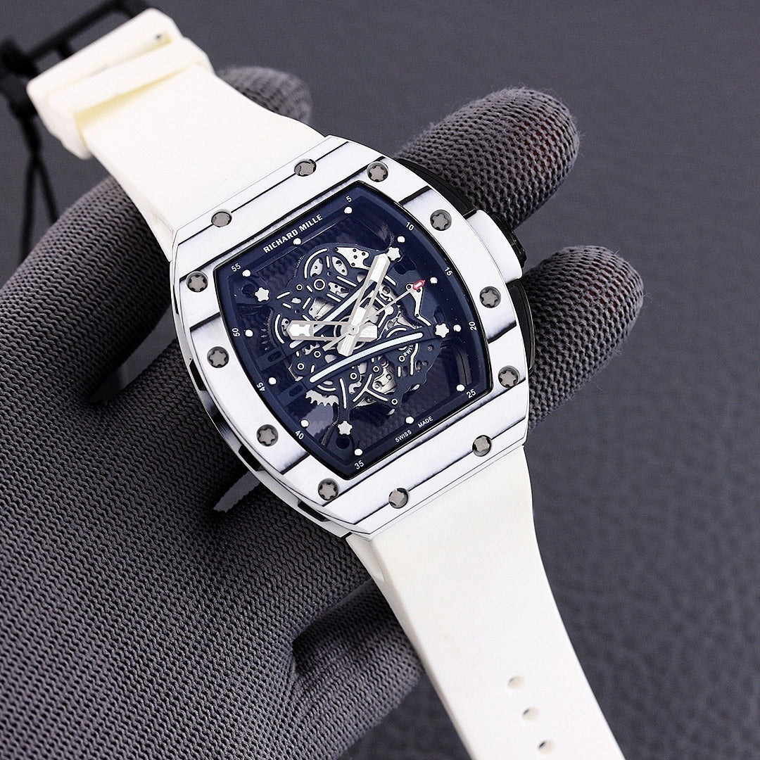Richard Mille watch with white-toned case, blue skeleton dial, and light beige rubber strap.