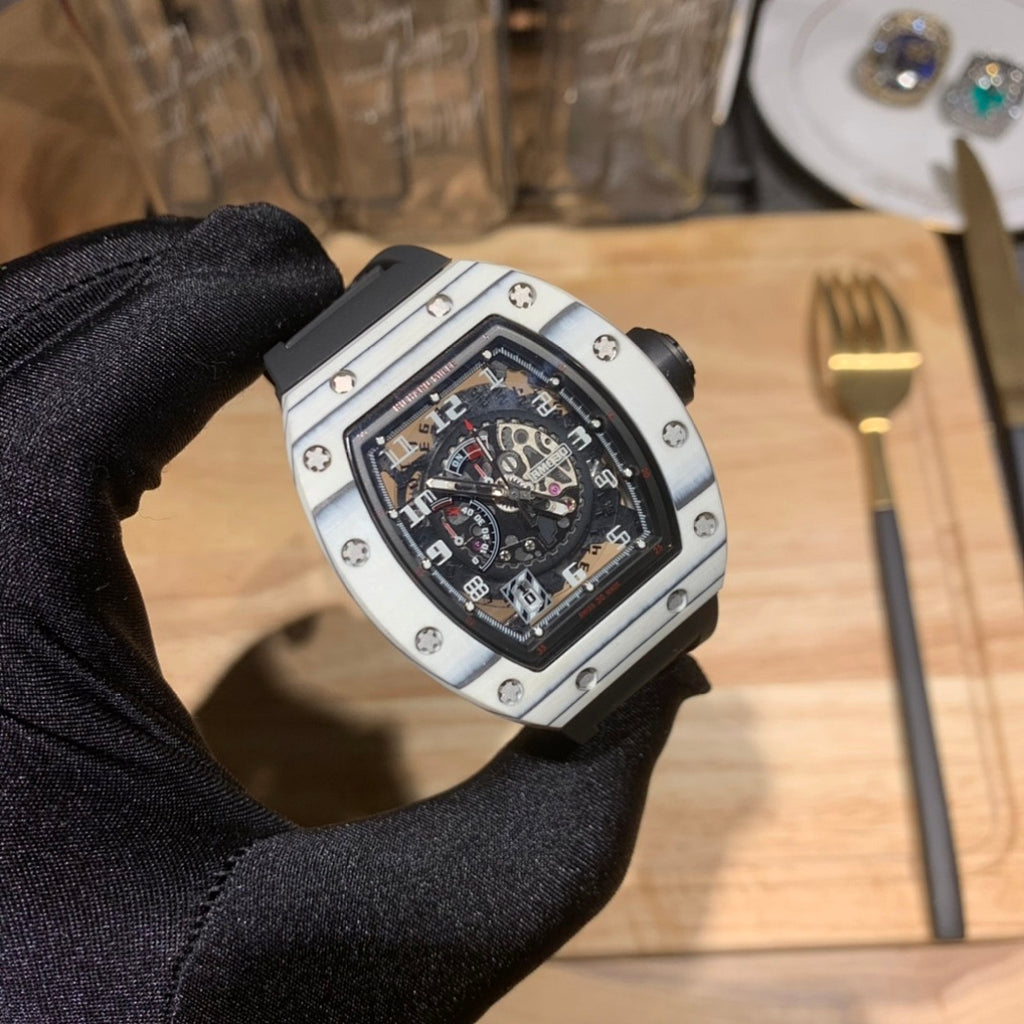 Richard Mille watch close-up with black dial, silver bezel, and black rubber strap