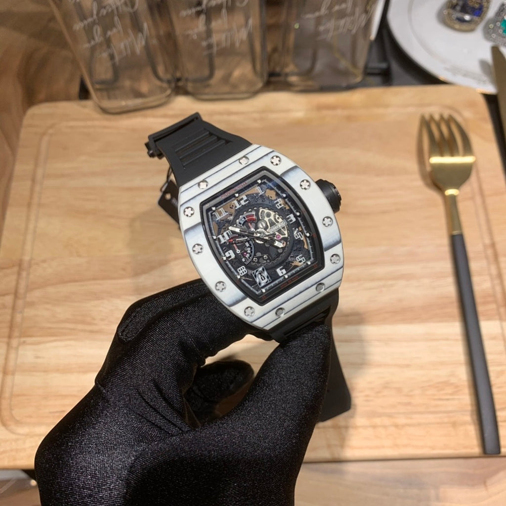 Richard Mille watch angled view, black dial, silver case, and black rubber strap