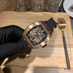 Richard Mille skeleton dial watch with black strap and rose gold-toned case, side angle