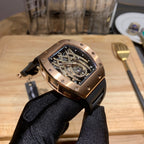 Richard Mille skeleton watch held upright, black rubber strap, rose gold-toned case