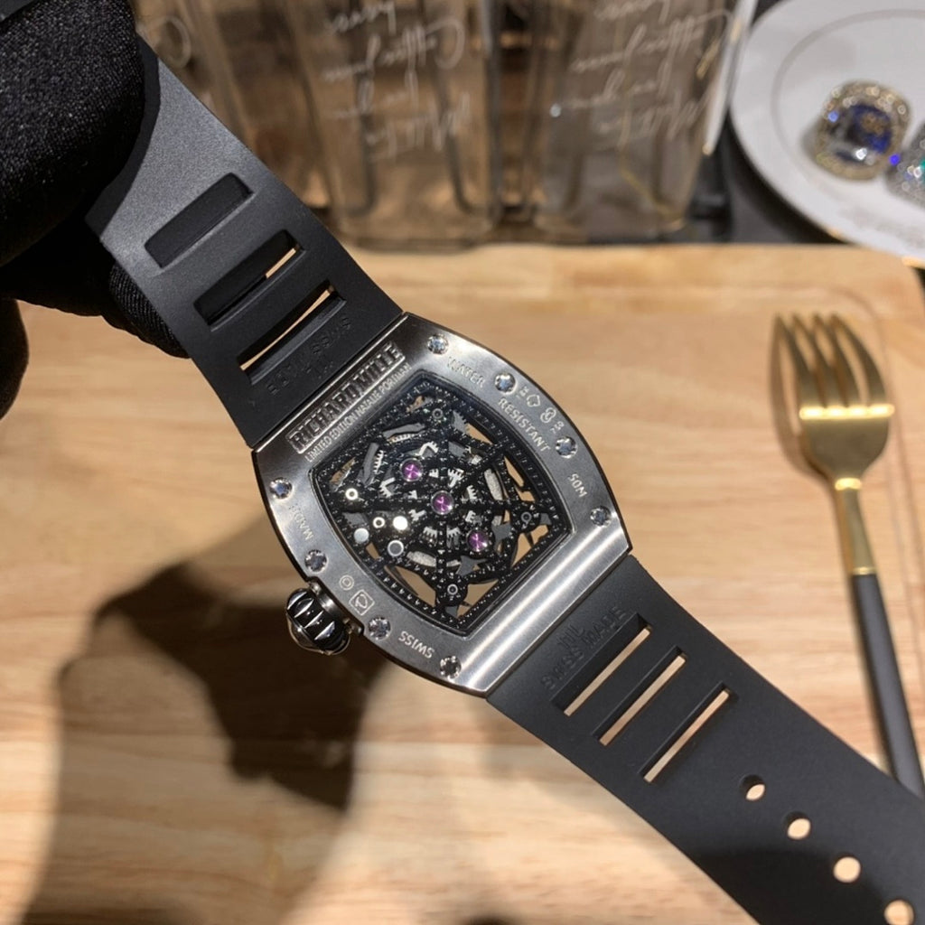 Richard Mille watch side profile, black rubber strap with metal accents, jeweled bezel