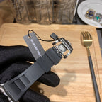Richard Mille watch strap detail with hanging tag, black rubber band and metal case bezel