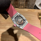 Richard Mille watch back view: pink strap, silver case, visible mechanical skeleton movement