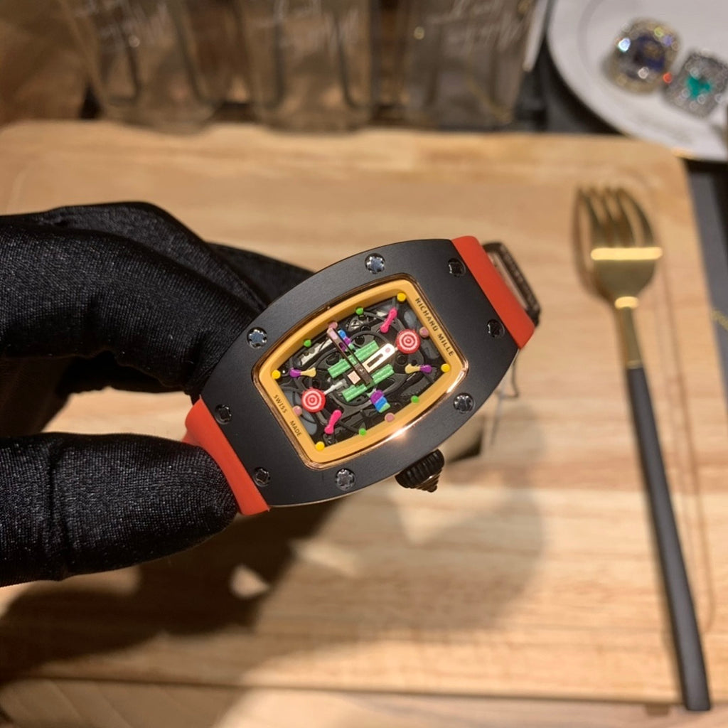Watch side view: black case with gold bezel and colorful dial, orange strap