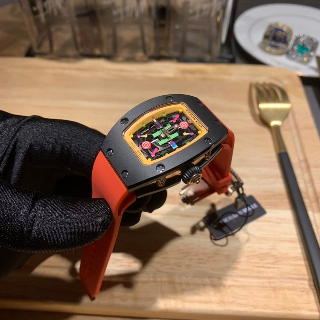 Watch close-up with orange silicone strap and black case, colorful transparent dial