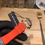 Watch strap and clasp: orange silicone band with metal buckle components