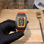 Richard Mille watch with black case, orange strap, and colorful transparent dial display