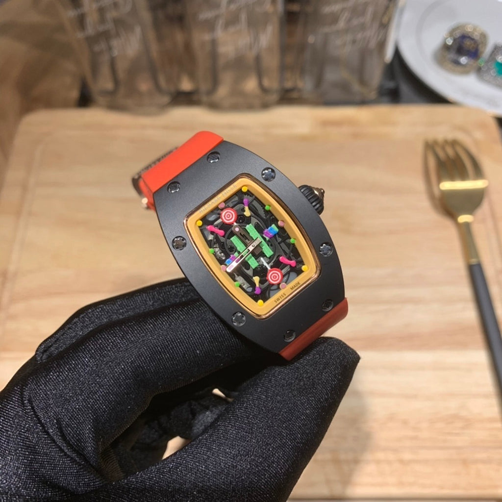 Watch on hand: black case with gold bezel, orange strap, colorful skeleton-style dial