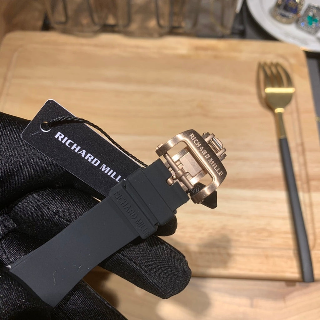 Black Richard Mille watch on strap, branded black band and metal buckle