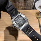 Richard Mille wristwatch side view, black strap and steel case with engraved markings