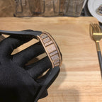 Diamond-set watch case side view with black rubber strap