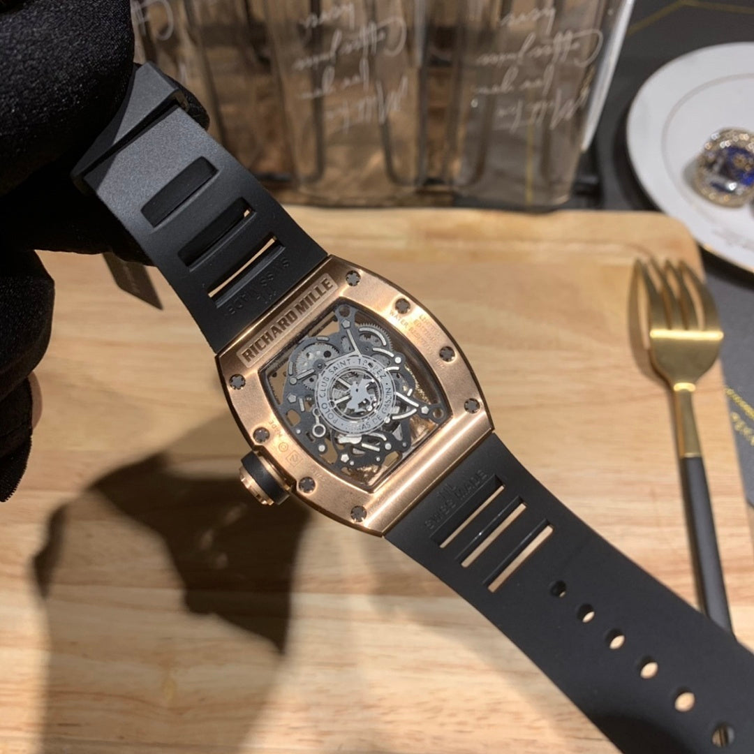 Black rubber strap watch with exposed caseback and rose-gold tone hardware