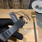 Black rubber watch strap with buckle and Richard Mille tag on gloved hand