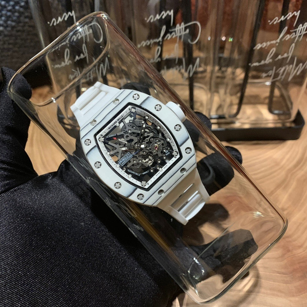 White strap luxury wristwatch with skeleton dial inside a clear protective cover