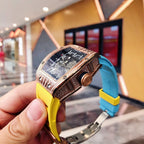Richard Mille watch angled side view with rose-gold case and yellow silicone strap