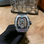 Skeleton wristwatch with jeweled bezel and black strap, front view