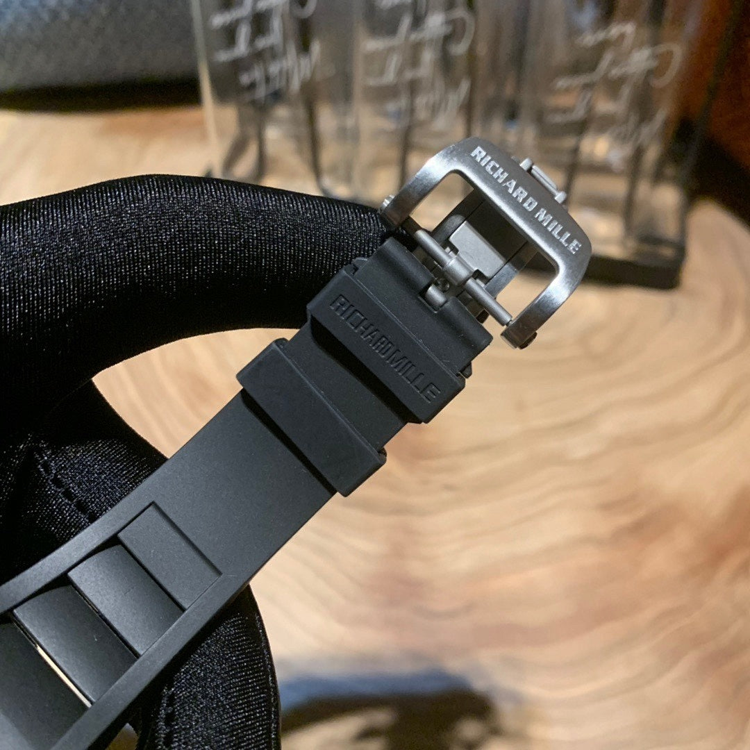 Luxury wristwatch black rubber strap with metal buckle and brand engraving