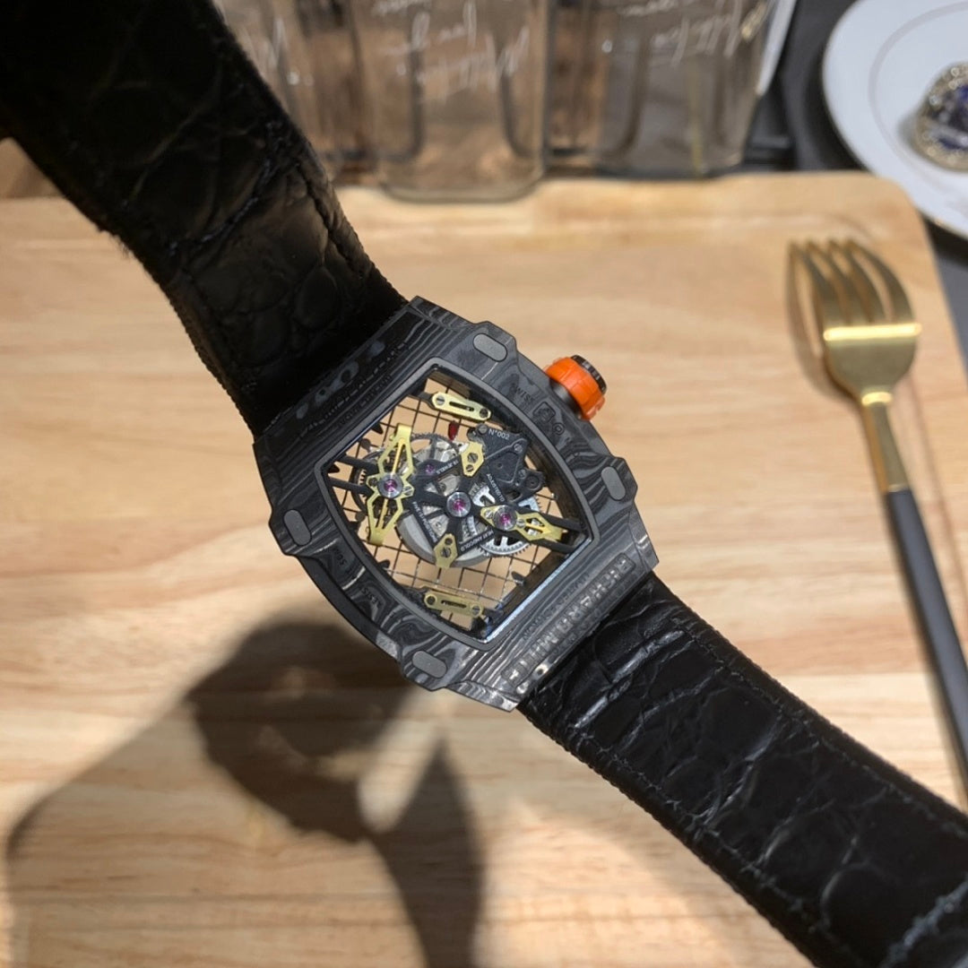 Richard Mille watch on wrist with black leather strap and orange-capped crown