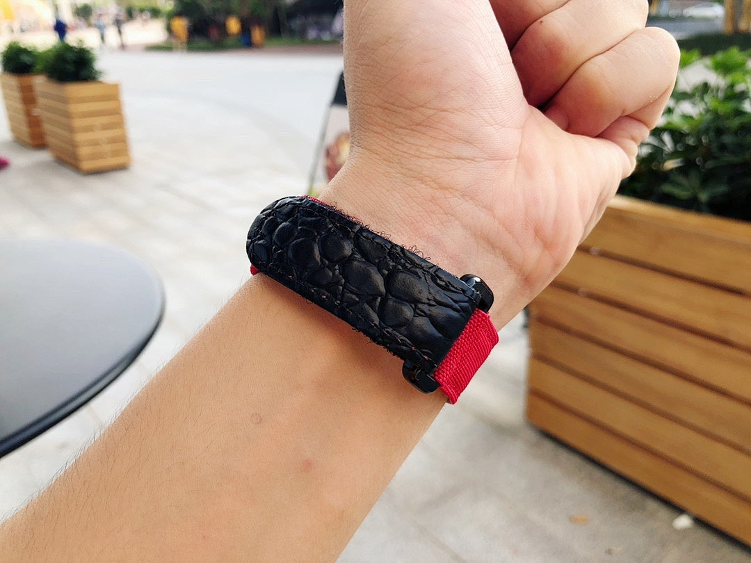 Richard Mille wristwatch strap close-up, black textured leather with red band trim