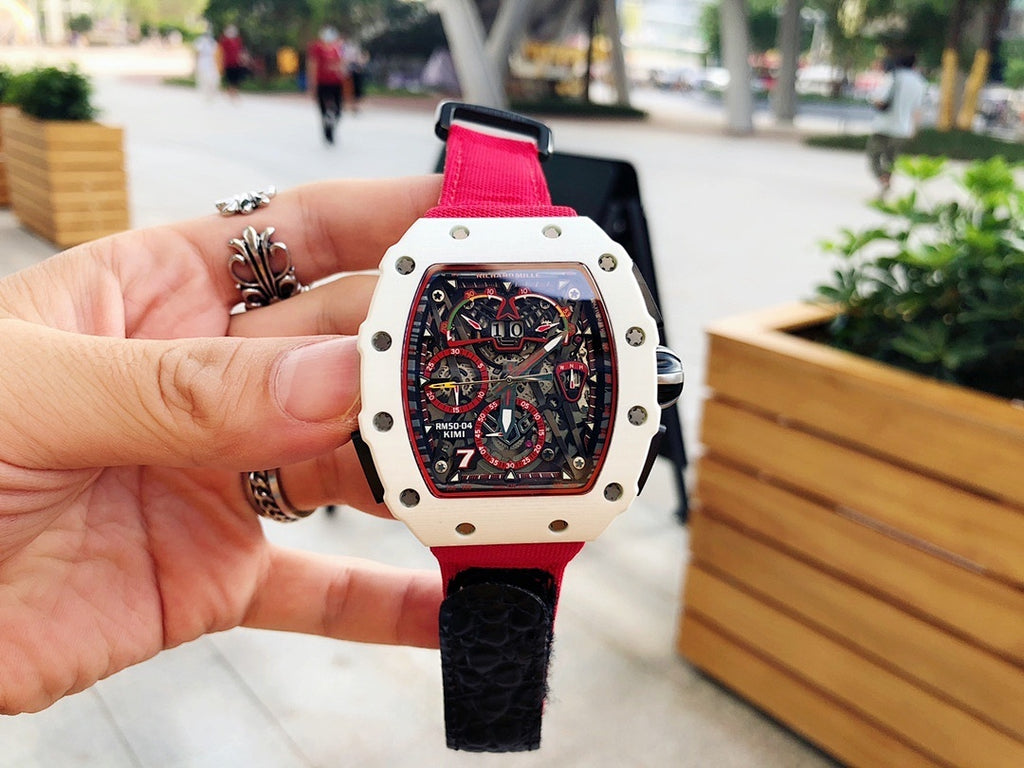 Richard Mille wristwatch front view in hand, red strap and light case with skeleton dial