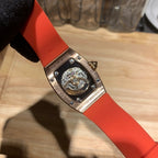 Richard Mille watch case back with visible mechanical dial and red-orange strap
