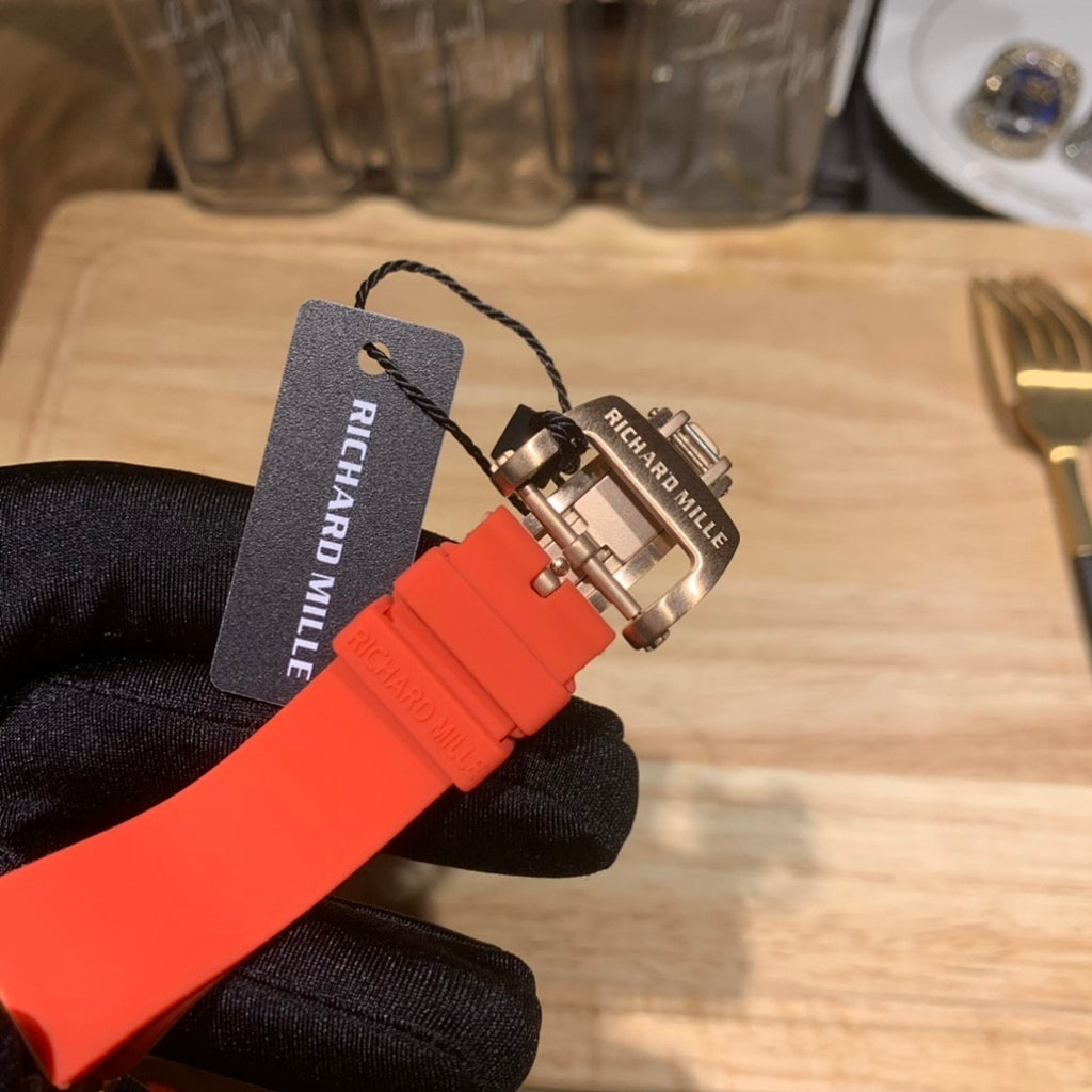 Richard Mille watch strap with tag and clasp hardware on red-orange band