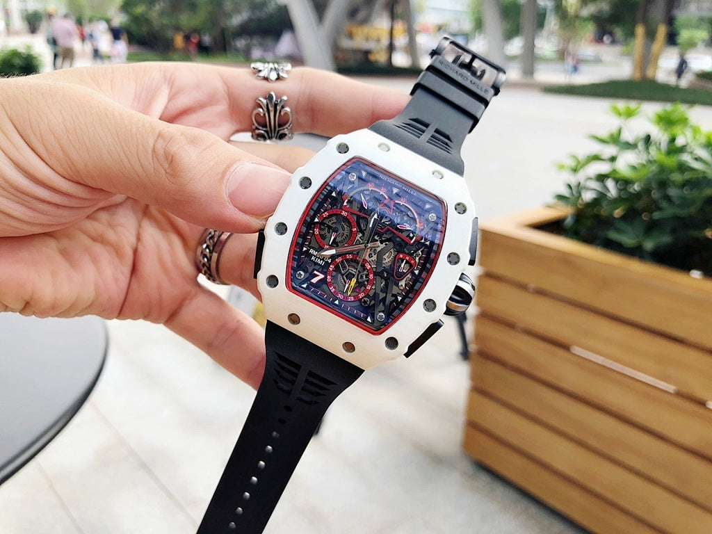 Richard Mille wristwatch held in hand, white case with skeleton dial and black rubber strap