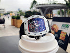 Richard Mille wristwatch on stand, white case, black strap, skeleton dial with red detail