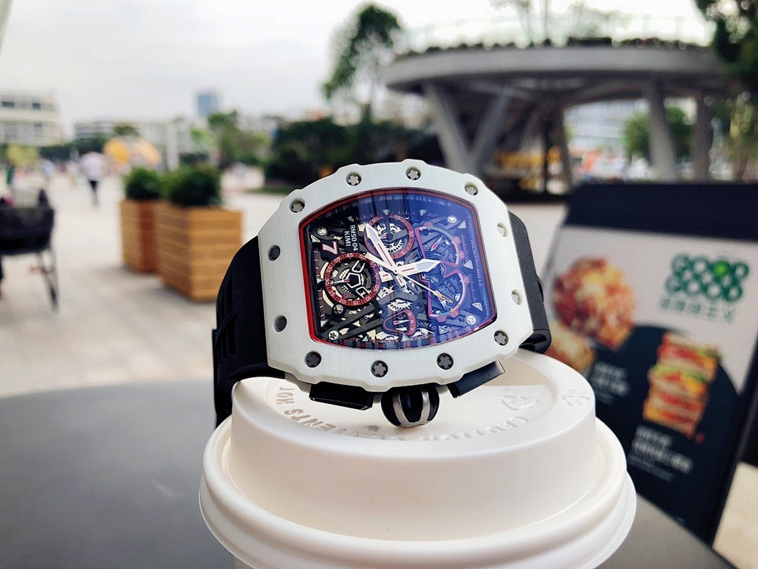 Richard Mille wristwatch on stand, white case, black strap, skeleton dial with red detail