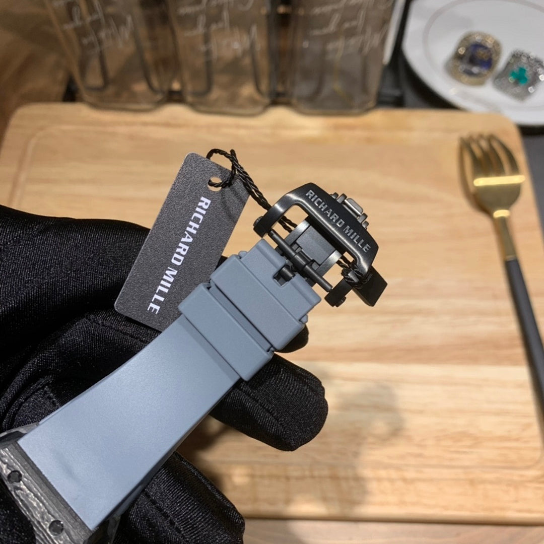 Richard Mille watch with light blue rubber strap and buckle hardware in hand
