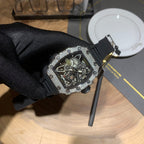 Black rubber-strap skeleton watch with jeweled bezel, angled view