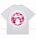 Light gray Stussy T-shirt with large circular graphic and pink camo face print