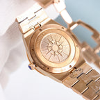 Rose gold wristwatch case back with engraved sun emblem and bracelet links